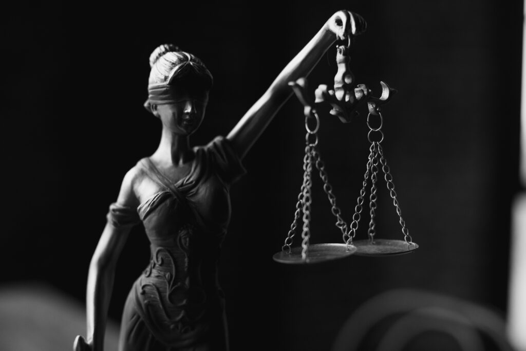 This is a black and white photo f a lady justice holding the scales while blindfolded.